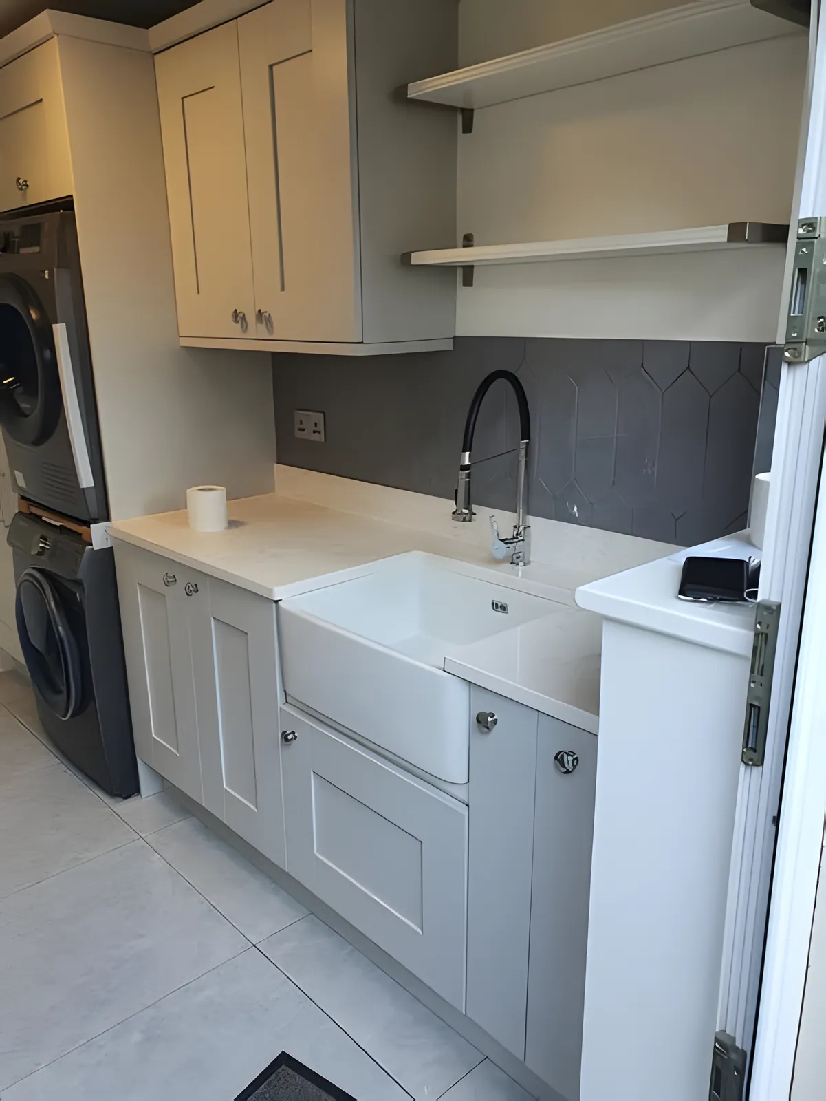 Butler sink with a black and chrome tap in a shaker-style utility room